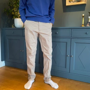 Beige chinos från These Glory Days - Snygga beige chinos från These Glory Days. De har en normal passform och är tillverkade i ett bekvämt bomullsmaterial. Perfekta för en stilren look.