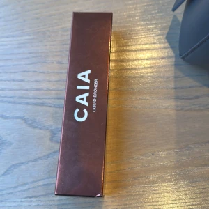 CAIA Liquid Bronzer Belize - Snygg flytande bronzer från CAIA i nyansen Belize. Perfekt för att ge ansiktet en solkysst look. Kommer i en elegant förpackning. Den är helt oöppnad 