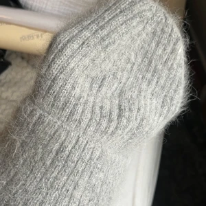 Grå stickad mössa - Mysig grå stickad mössa med ribbad design. Perfekt för kyliga dagar och håller dig varm och stilren. Enkel att matcha med olika outfits.