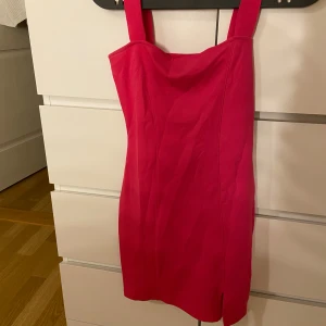 Skrik-rosa klänning - Skrik-rosa klänning som tjocka band upptill🩷Den är kort, har en liten slit nedtill & är formad efter kroppen som man kan se på bild 4🩷Använd endast en gång!
