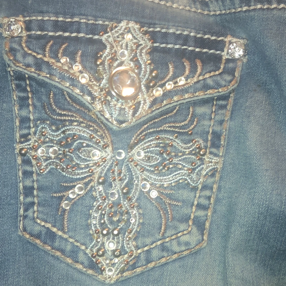 Blå jeans med broderade bakfickor med gems