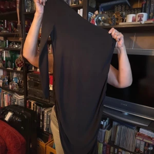 Svart långklänning - Elegant svart långklänning med en smickrande passform. Perfekt för en stilren look.