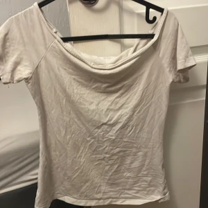 Vit offshoulder topp från Basic - Säljer en stilren vit offshoulder topp från Basic. Perfekt för en avslappnad look. Toppen har korta ärmar och en mjuk, bekväm passform.