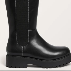 Svarta boots med resår - Snygga svarta boots i skinn med resårdetaljer på sidan. Perfekta för en stilren look med robust sula för extra komfort.