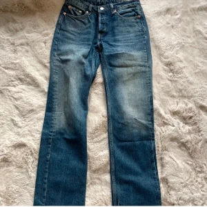 Blå jeansbyxor - Säljer ett par klassiska blå jeansbyxor med låg midja och straight passform. Perfekta för en avslappnad stil. De har 4 fickor och 1 knapp i midjan.