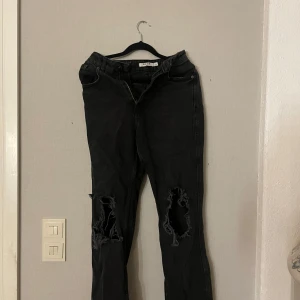 Svarta jeans med slitningar från NA-KD - Snygga svarta jeans från NA-KD med slitningar, rak passform