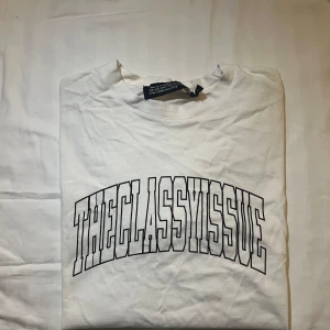 Vit t-shirt från The Classy Issue - Säljer en vit t-shirt från The Classy Issue med tryck i svart på framsidan. Samarbete med Na-kd. 