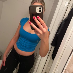 Blå topp från Shein - Säljer en snygg blå topp från Shein. Toppen har en rundad halsringning och är kortärmad, perfekt för sommardagar. Den är tillverkad i ett mjukt och bekvämt material. Jag är 172 cm lång och bär 