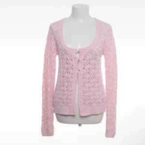 Rosa stickad kofta - Söt rosa stickad kofta med ett fint hålmönster. Koftan har långa ärmar och tre knappar framtill. jättefint att styla med ett linne under, den har inga defekter och är i nyskick. Pris KAN diskuteras vid SNBB affär!