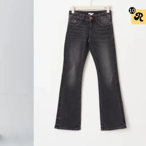 Svarta jeans från Gina Tricot - Snygga svarta jeans från Gina Tricot i storlek 164. De har en klassisk femficksdesign med knappar på bakfickorna och en knappgylf framtill. Perfekta för en stilren look. Nypris: 400kr