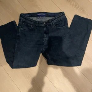 Mörkblå jeans från Jacob Cohen - Snygga mörkblå jeans från Jacob Cohen med klassisk femficksdesign. De har en dragkedja och knapp framtill samt ett stilrent märke på baksidan. Perfekta för en avslappnad look.