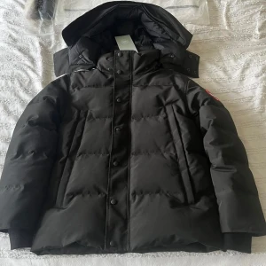 Canada Goose Wyndham - Säljer en svart wyndham från Canada Goose med pälsdetaljer på huvan. Jackan är för liten för mig. Perfekt för kalla vinterdagar. Det är Size S ( inte M)