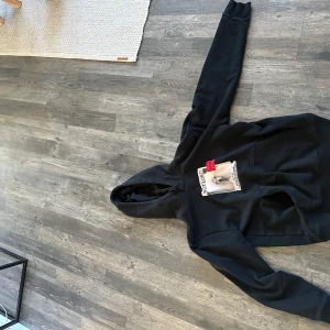 Svart hoodie från Hugo - Säljer en svart hoodie från Hugo med en unik tryckdetalj på framsidan. Hoodien har en klassisk design med långa ärmar och en bekväm passform. Perfekt för en avslappnad stil.