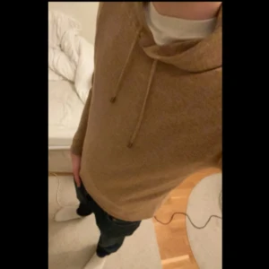 Stickad hoodie - Säljer en snygg beige stickad hoodie med dragsko i huvan. Perfekt för kyliga dagar och ger en avslappnad stil. Passar bra till jeans eller chinos. Skriv för fler bilder eller om ni har frågor🙌