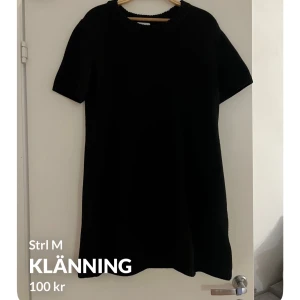 Svart klänning från H&M - Säljer en stilren svart klänning från H&M i storlek M. Klänningen har korta ärmar och en enkel design som passar perfekt för olika tillfällen. Perfekt basplagg att ha i garderoben!