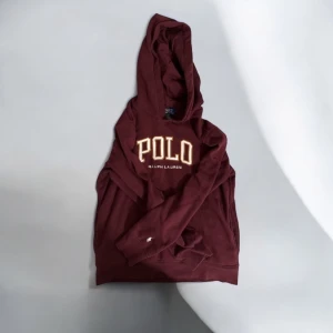 Vinröd hoodie från Ralph Lauren - Säljer en riktigt fet äkta vinröd hoodie från Ralph Lauren med stor POLO-logga på framsidan och det klassiska hästlogotypen på ärmen. Passar folk mellan 160-170 cm. Perfekt för en avslappnad stil med en touch av lyx.