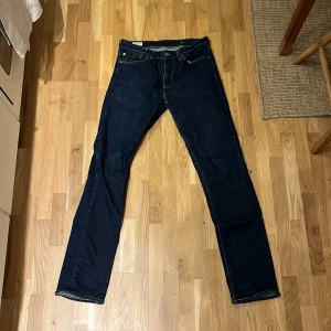 Mörkblå jeans från Levi's 511 - Säljer ett par klassiska mörkblå Levi's 511 jeans. De har en slim passform och är tillverkade i slitstarkt denim. Perfekta för en stilren look.