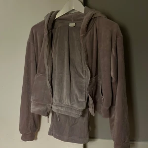 Lila velour hoodie och byxor - Mysig lila hoodie i velour med dragkedja. Matchande byxor i samma mjuka material. Perfekt för en avslappnad stil.