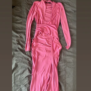 Rosa långklänning med djup v-ringning - Snygg rosa långklänning med djup v-ringning och långa ärmar. 