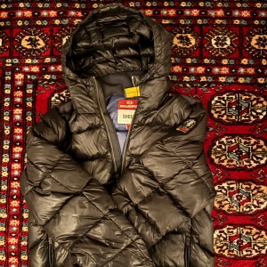 Svart dunjacka från Parajumpers - Säljer en svart dunjacka från Parajumpers med huva och dragkedja. Jackan är quiltad och perfekt för kalla dagar. Den har en snygg och stilren design med en logga på ärmen.