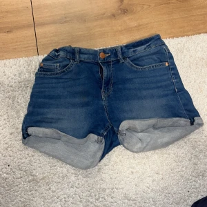 Blå jeansshorts från Lindex - Säljer ett par snygga blå jeansshorts från Lindex. De har en klassisk design med fem fickor och uppvikta benslut. Perfekta för en avslappnad stil. Passar superbra på mig som har storlek S!!!!!💋💋