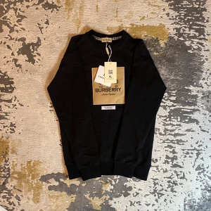 Tröja - Säljer en snygg svart tröja från Burberry i storlek S. Tröjan är i nytt skick och har en klassisk design med Burberry-logga på bröstet. Perfekt för både vardag och fest! 🖤