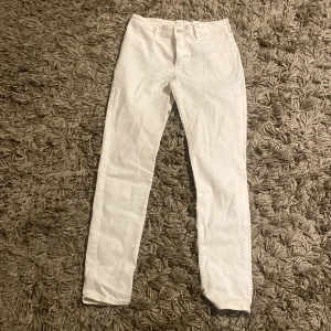 Vita skinny jeans från &Denim - Snygga vita skinny jeans från &Denim i storlek 158. Perfekta för en stilren look med sin tighta passform och klassiska design. Tillverkade i ett bekvämt material som ger en skön känsla hela dagen.