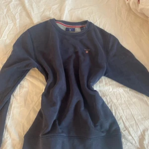 Marinblå gant tröja - Mysig långärmad tröja från gant med vacker marinblå färg och liten logga. Perfekt till ett par snygga jeans.