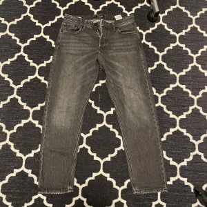 Loose fit jeans - Snygga grå jeansbyxor med en klassisk loosefit passform. De har fem fickor och en dragkedja framtill. Perfekta för en avslappnad stil. 32/32