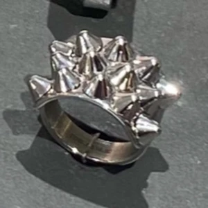 Silvrig ring med nitar - Cool och edgy ring i silverfärg med flera nitar som sticker ut. Perfekt för att ge din outfit en tuffare look. Passar bra till både vardag och speciella tillfällen.