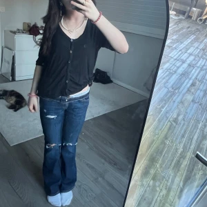 Svart kofta med knappar - Säljer en stilren svart kofta med knappar framtill. Perfekt för en avslappnad look. Koftan har trekvartsärmar och en bekväm passform.