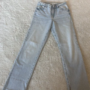 Ljusblå jeans med slits - Snygga ljusblå jeans från MISL i storlek 32. De har en rak passform och coola slitsar vid bensluten. Perfekta för en avslappnad stil. Tillverkade i jeansmaterial med klassisk dragkedja och knapp.