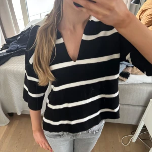 Svart och vit randig tröja  - Säljer en stilren svart och vit randig tröja från Sisley. Tröjan har en v-ringad hals och trekvartsärmar, perfekt för en avslappnad look, strl xs🤍