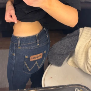 Mörkblå bootcut jeans från Wrangler - Snygga mörkblå bootcut jeans från Wrangler!! W:26 L:32 (35cm över midjan)