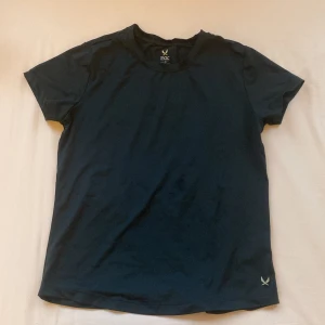 Svart tränings tröja - Säljer en svart t-shirt från SOC i storlek XS. Den har korta ärmar och är tillverkad i ett tekniskt material som håller dig torr och bekväm under träning. 😊