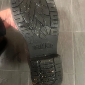 Bruna boots från Johnny Bulls - Snygga bruna boots från Johnny Bulls i skinn med två guldfärgade spännen. Perfekta för en stilren look med robust sula och dragkedja på insidan för enkel på- och avtagning.