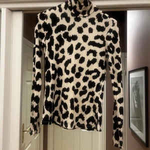 Tight leopardprint tröja - Jättefin tröja med tight passform och turtleneck hals/polokrage. Använd ett fåtal gånger, därför i väldigt bra skick, som ny. 