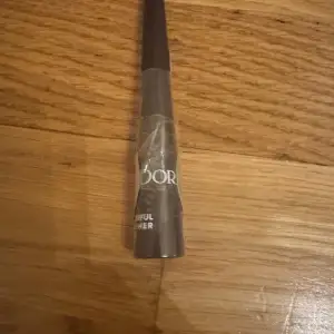 Flytande eyeliner i färgen mörkbrun från IsaDora. Perfekt för att skapa en definierad och intensiv look. Kommer i en smidig förpackning med en precis applikator för enkel applicering.