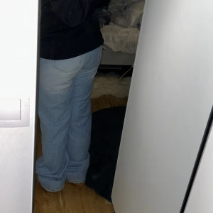 Ljusblå jeans med bootcut - Säljer ett par ljusblå jeans med bootcut-stil. De har en klassisk femficksdesign och är högmidjade för en bekväm passform. Perfekta för en avslappnad look. De är typ rakbootcut