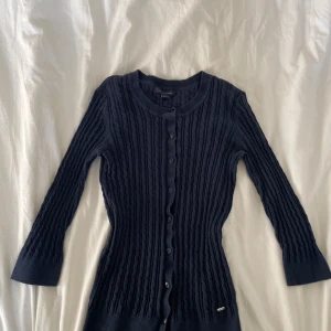 Mörkblå ribbad kofta från Tommy Hilfiger - Säljer en stilren mörkblå kofta från Tommy Hilfiger. Den är ribbad med knappar framtill och har långa ärmar. Perfekt för en klassisk look. 🧥Passformen är lite liten.
