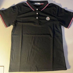 Svart pikétröja från Moncler - Moncler Svart Piké – Storlek S – Ny  Säljer en helt ny och oanvänd svart Moncler piké i storlek S. Skicka ett meddelande vid intresse!