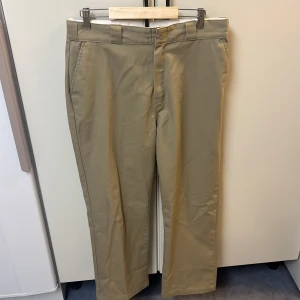Dickies work pant  - Snygga beige byxor från Dickies med dragkedja och knappstängning. Perfekta för en stilren look. Byxorna har en klassisk passform och är tillverkade i ett slitstarkt material.