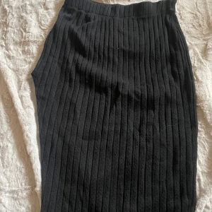 Svart ribbad kjol från Shein - Snygg svart ribbad kjol i en klassisk design. Kjolen har en tight passform och är perfekt för en stilren look. Den är gjord av ett mjukt och stretchigt material som ger en bekväm känsla.