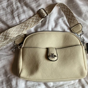 Väsk  - Helt oanvänd handväska, köpt i Frankrike. Tror det är en ”the bee bag” väska. Nypris 1200. Är ljus beige. Höjd 21 cm, bredd 28 cm, djup 6 cm. Skriv om du har frågor💕