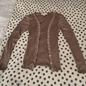 Brun silkeskofta från Style Butler - Säljer en söt brun kofta från Style Butler i 100% silke. Koftan har långa ärmar och fina spetsdetaljer längs kanterna. Och har en stretchig passform 🧡