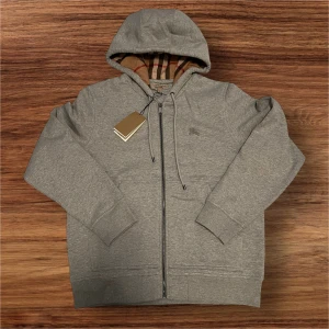 Grå Burberry Kofta Storlek Large  - Säljer en helt ny, grå Burberry kofta i storlek Large. Koftan är aldrig använd och har fortfarande alla taggar kvar. En tidlös och stilren design som passar både till vardags och till finare tillfällen.