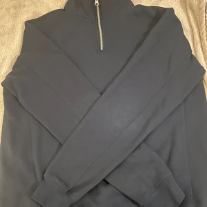 Mörkblå tröja med dragkedja från Zara - Säljer en stilren mörkblå tröja från Zara med halv dragkedja vid halsen. Tröjan har långa ärmar och är perfekt för kyligare dagar. Passar bra till både jeans . Perfekt för en avslappnad look. Använd max 5 gånger