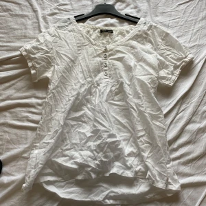 Söt blus - Säljer en vit blus från Eve i medium storlek. Blusen har korta ärmar och knappar framtill. Perfekt för en avslappnad stil. Ganska genomskinlig 