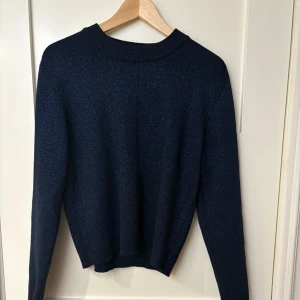 Svart glittrig tröja från Carin Wester - Säljer en snygg svart glittrig tröja från Carin Wester. Tröjan har långa ärmar och en klassisk rund halsringning. Perfekt för att lägga till lite glitter i vardagen. Passar bra till både jeans och kjol. ✨