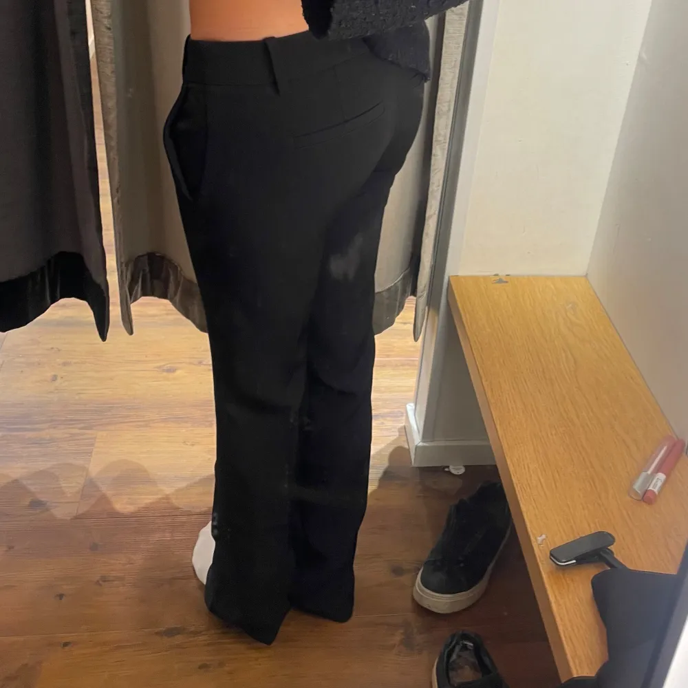 Snygga svarta kostymbyxor med låg midja och en klassisk straight passform. Perfekta för en stilren look. Byxorna har diskreta fickor och en enkel design som gör dem mångsidiga. Har gjort en egen slit så dom ska ligga snyggare på skorna🥰. Farkut & Housut.